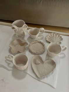 some white dishes and spoons on a table