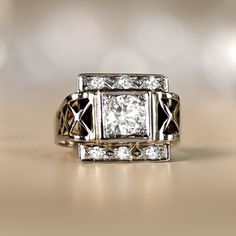 This vintage Retro era ring features a 0.75 carat round brilliant cut diamond, I color and VS1 clarity. Above and below the center stone is a geometric design set with single cut diamonds. The shoulders display lacy open-work. This ring is 18k white gold, and was made in France circa 1945. ✦ DIAMOND SPECIFICATIONS: Diamond Weight: 0.75 Carats Diamond Color: I Color Diamond Clarity: VS1 Color Diamond Cut: Round Brilliant Cut ✦ ENGAGEMENT RING SPECIFICATIONS: Material: 18k White Gold Stones: Diamo Classic Collectible Diamond Ring With Vvs Clarity, Vintage White Gold Signet Ring With Center Stone, Classic Collectible Diamond Ring With Center Stone, Classic Collectible Cluster Ring With Diamond Cut, Classic Hallmarked Cluster Ring In 14k White Gold, Classic Hallmarked 14k White Gold Cluster Ring, Classic Diamond Signet Ring Collectible, Classic Collectible Rings With Diamond Accents, Classic Rings With Diamond Accents For Collectors