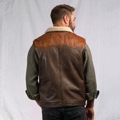 Our iconic western vest was inspired by the high mountain valleys of the Bison State. Built with a quality and craftsmanship worthy of our brand and our name. The open-arm Western Yoke exterior features 100% full grain lambskin leather, secured by a top-to-bottom antique nickel zipper with optional button-down flap and framed by twin front side pockets. Our sherpa-style polyester interior lining extends through the classic fold over collar… providing lasting comfort and mobility from the barn to Rugged Outdoor Winter Vest, Rugged Winter Vest For Outdoor Activities, Sleeveless Brown Outerwear For Outdoor, Leather Winter Outdoor Vest, Rugged Fall Vest Outerwear, Rugged Brown Winter Vest, Brown Rugged Winter Vest, Brown Rugged Vest For Winter, Outdoor Leather Vest With Pockets