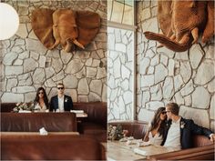 two people sitting at a table in front of an elephant head