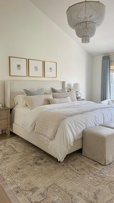 a large bed sitting in the middle of a bedroom next to a window with curtains