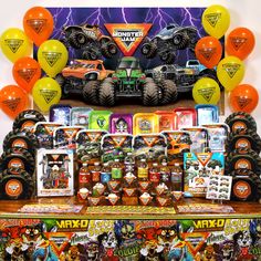 monster trucks and balloons are on display in front of a birthday party sign with an assortment of toys