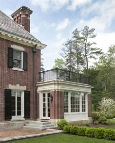 a brick house with black shutters and white trim