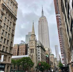 a city street with tall buildings in the background