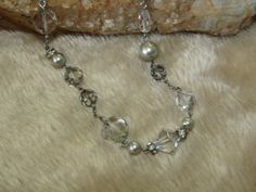 "Vintage Carolee silver tone necklace, adorned with silver faux pearls, clear glass crystals, clear faux crystals, smoky grey faux crystals, and rhinestone rings. Necklace measures 16\" long, with a 2\" extender, which is coppered, as well as the lobster clasp. Tagged with a heart charm signed Carolee. Necklace may need some cleaning." Silver Rhinestone Necklace With Pearl Chain, Elegant Silver Crystal Necklace With Pearl Chain, Formal Silver Rhinestone Necklace With Pearls, Formal Silver Rhinestone Pearl Necklace, Silver Pearl Rhinestone Necklace For Formal Occasions, Formal Silver Pearl Rhinestone Necklace, Silver Crystal Pearl Necklace With Rhinestones, Silver Beaded Crystal Pearl Necklace, Silver Crystal Beaded Pearl Necklace