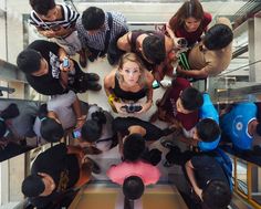 a group of people standing around each other in a circle on an escalator