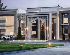 this is an image of a modern style house at night with cars parked in the driveway