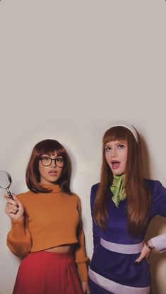 two young women dressed in retro clothing posing for the camera