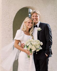 a bride and groom pose for a wedding photo