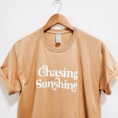 Get out there and ﻿chase sunshine in this perfect simple boho vibe t-shirt for the summer. Lee Fletcher, Printed Shirts For Women, Positive Shirts, Western Tees, Flower Business, Gold Shirt, Positive Shirt, Sublimation Ideas, Christian Tees