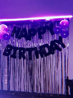 purple and black happy birthday balloons hanging from the ceiling