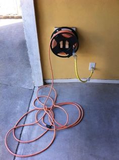 an electric cord connected to a wall mounted outlet on the side of a yellow building