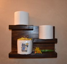 two wooden shelves holding toilet paper and other items