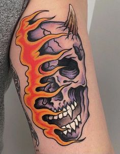 a woman's arm with a skull and flames on it