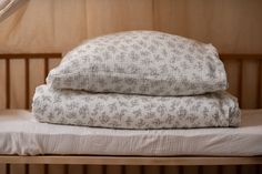 two pillows are stacked on top of each other in front of a wooden headboard