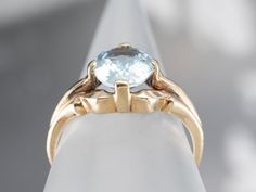 This stunning aquamarine has been set into this Retro era solitaire ring. The cool blue tones contrast beautifully with the warmth of the vintage mounting, while the tapered shoulders draw light into the sparkling gem. This is a lovely piece that is pretty enough to wear alone, yet versatile enough to stack with other rings!Metal: 10K Yellow GoldGem: Aquamarine 1.37 CaratsGem Measurements: 8.5 x 6.9 mm, OvalRing Size: 5.25Marks: "10K" Stamped on the inside band Classic Blue Topaz Solitaire Ring, Classic Blue Topaz Birthstone Ring, Classic Birthstone Ring With Round Cut Blue Topaz, Classic Round Cut Blue Topaz Birthstone Ring, Classic Blue Topaz Birthstone Ring, Round Cut, Classic Aquamarine Diamond Ring With Prong Setting, Classic Blue Topaz Ring With Round Band, Classic Light Blue Topaz Ring For Formal Occasions, Classic Aquamarine Diamond Ring