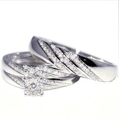 two white gold wedding rings with diamonds on each one and an engagement ring in the middle