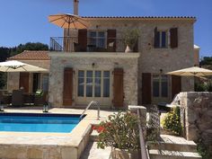 an outdoor swimming pool next to a stone house