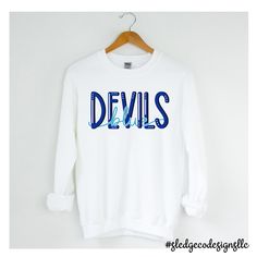 BLUE DEVILS | TUNICA ACADEMY | UNISEX SWEATSHIRT Cheer on your team in style with this Tunica Academy SWEATSHIRT! Show your team spirit, this one-of-a-kind hand-drawn crewneck is sure to impress! Please allow 2-3 WEEKS (NOT INCLUDING) business days for processing - THESE ARE MADE TO ORDER! If preorder - these we process after preorder date. - You will be notified by email on when your order is ready! We are located in Olive Branch. All our items are completely custom, and made to order for a uni Blue Team Name Sweatshirt For Fall, Blue Team Sweatshirt For Fall, Casual Blue Pre-shrunk Sweatshirt, Blue Collegiate Pre-shrunk Sweatshirt, Collegiate Blue Pre-shrunk Sweatshirt, Blue Team Name Sweatshirt For Sports Season, Blue Sweatshirt With Team Name For Sports Season, Blue Sweatshirt With Team Name For Streetwear, Blue Varsity Sweatshirt With Graphic Print