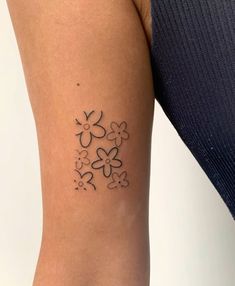 a woman with a tattoo on her arm that has flowers in the shape of hearts