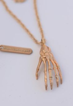 "In ancient times, the meaning of a skeleton hand is the symbol of mortality and the transitory nature of life. " Crafted with care from bronze or sterling silver, this exquisite skeleton hand is a unique work of art. Rope chain 20” Length + 2” extension Handcrafted in Los Angeles. Brass Claw Jewelry As Gift, Unique Bone Colored Sterling Silver Jewelry, Unique Bone-colored Sterling Silver Jewelry, Symbolic Rose Gold Brass Jewelry, Hand Cast Metal Amulet Jewelry, Bone Colored Metal Jewelry Gift, Unique Hand Cast 14k Gold Jewelry, Hand Cast Yellow Gold Jewelry, Unique Bone-colored Jewelry For Gift