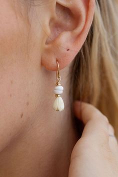 These dainty Pikake Puka shell drop earrings exude Hawaii's natural beauty. These gold earrings feature natural puka shells and carved pikake flower charms reminiscent of Hawai'i's flower leis. They are perfect solo or teamed with our other earrings. ✦ DETAILS ✦ ✧ Name: Kēhau (keh-how) - dewdrop. ✧ 14kt Gold Filled w/carved resin Pikake flowers and natural Puka shells. ✧ 3cm Drop Length ✧ All Ke Aloha Jewelry pieces come packaged thoughtfully, beautifully, and ready for gift giving. ✦ MORE EARRI White Teardrop Earrings Feminine Style, White Teardrop Feminine Earrings, Adjustable Teardrop Flower Earrings, Beige Drop Earrings With Ear Wire, Beige Dangle Jewelry With Ear Wire, Cream Flower Earrings For Gift, Beige Teardrop Jewelry For Gift, Adjustable Cream Drop Earrings, Beige Teardrop Jewelry Gift