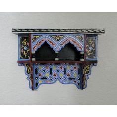 an artisticly painted wooden shelf on the wall