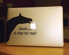 an apple laptop with a horse sticker on it's cover that says, ooh is that for me?