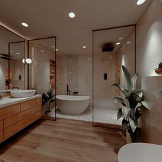 a large bathroom with two sinks and a bathtub in the middle of the room