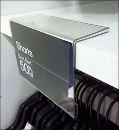 a close up of a metal shelf with black and white tags on it's sides