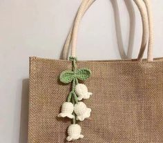 a bag with flowers on it hanging from the handle and two strings attached to it