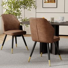 two brown chairs sitting on top of a rug in front of a black dining table