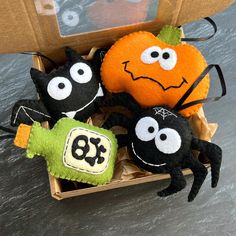 three stuffed animals in a box with halloween decorations