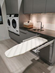 a white surfboard sitting on top of a kitchen counter next to a washer and dryer