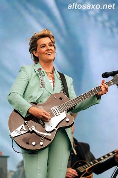 a woman playing an electric guitar on stage