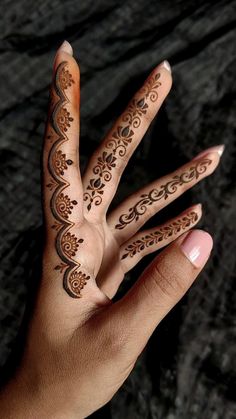 a person's hand with henna tattoos on it