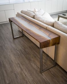 a wooden table sitting on top of a hard wood floor next to a white couch