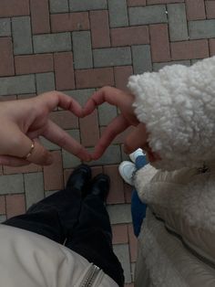 two people making a heart shape with their hands