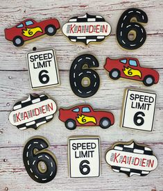 decorated cookies with cars and speed limit numbers are arranged on a wooden table, ready to be eaten