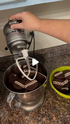 someone is making cookies in the kitchen with an electric hand mixer on top of it