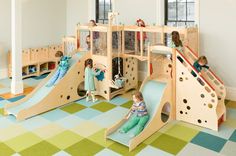 children playing in a play area with slides and climbing walls