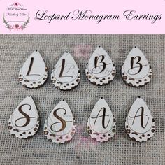 six wooden tear shaped monogram earrings with the letters s, b, c, and h