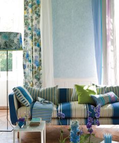 a living room filled with furniture and colorful pillows on top of it's couches