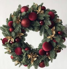 a christmas wreath with red and gold ornaments