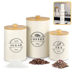 three white canisters with coffee logos on them and some beans next to it