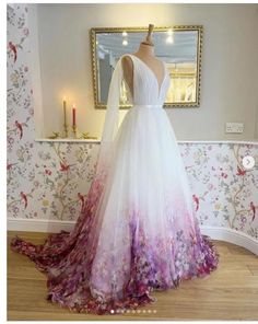 a white and purple wedding dress on display in front of a wallpapered room