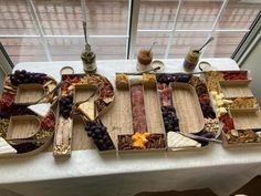 a table topped with trays filled with different types of food and drinks next to a window