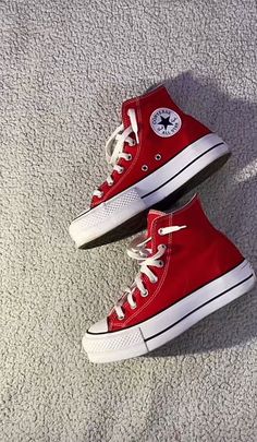 pair of red converse sneakers on white carpet