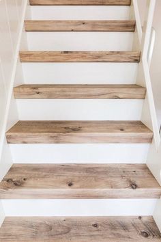 wooden stairs with white painted walls and wood flooring