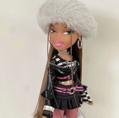 a doll is dressed in black and white with fur on it's head,